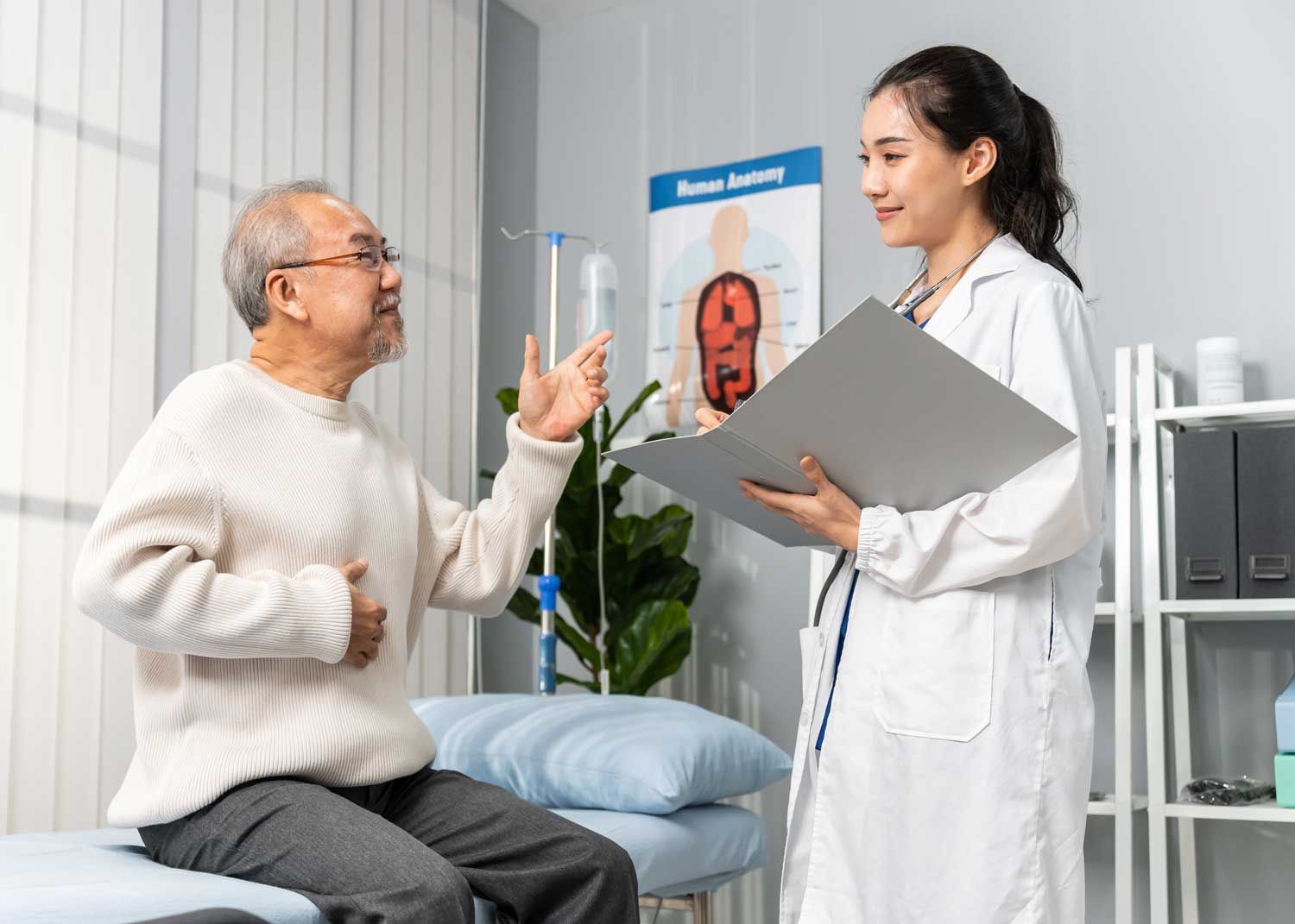 A woman sits on an exam table and talks to a nurse